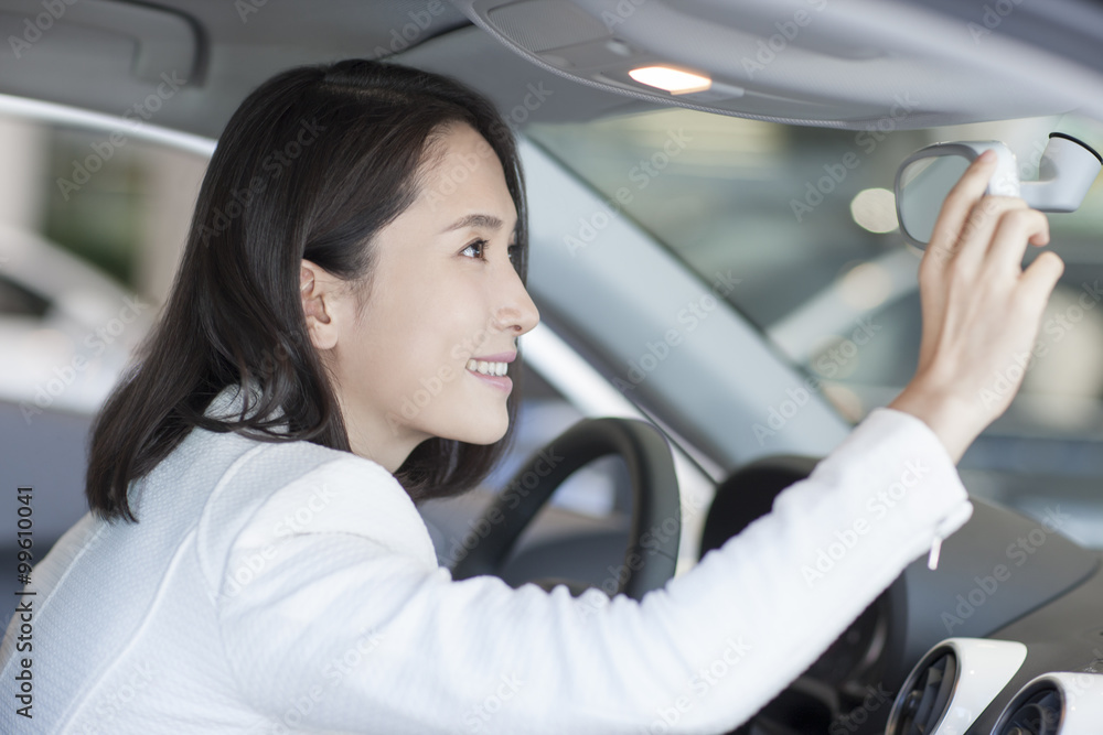 Young woman choosing car in showroom