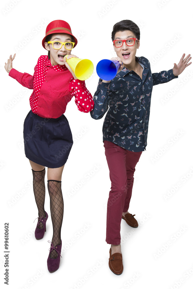 Young couple shouting through megaphones 