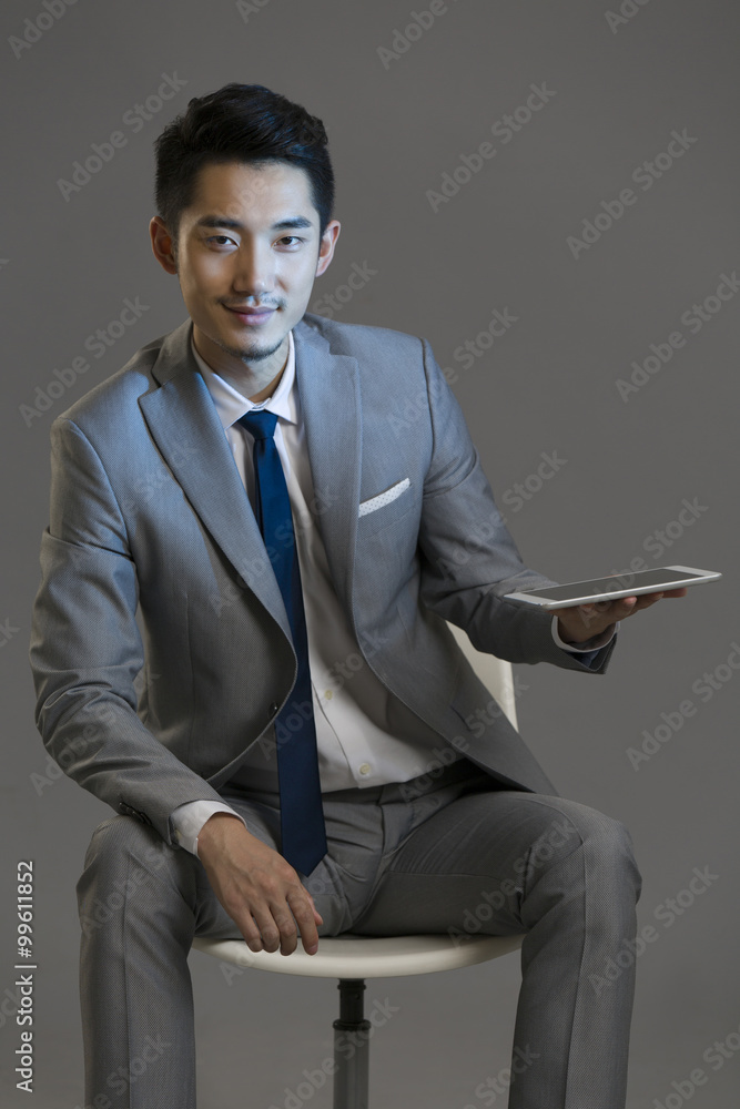 Happy young businessman using digital tablet