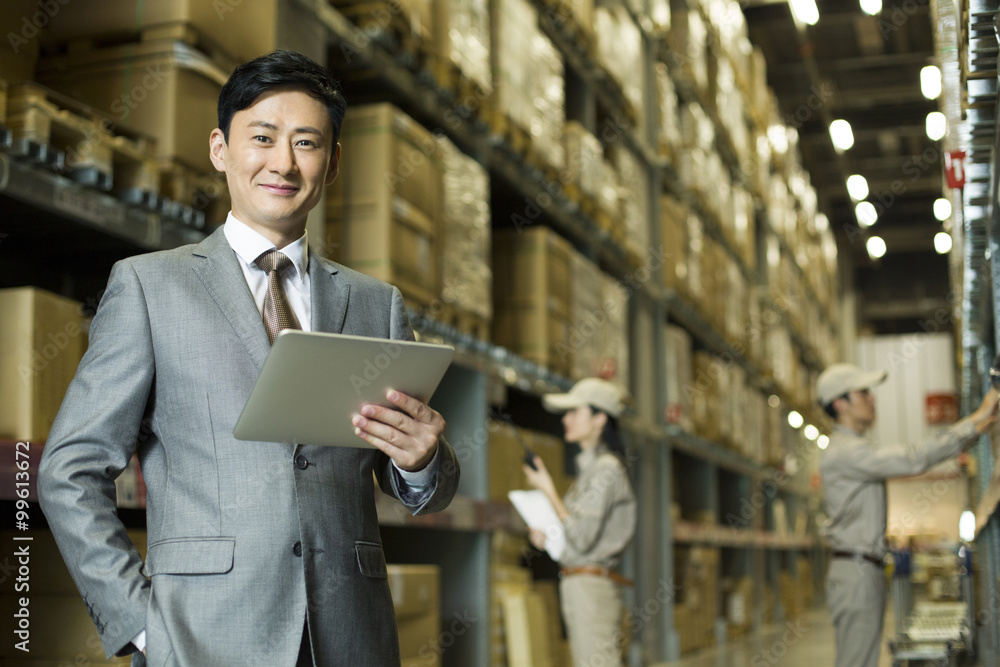 Businessman with digital tablet in warehouse