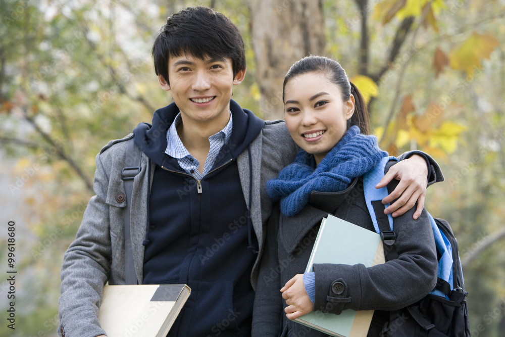 一对搂着胳膊摆姿势的大学情侣