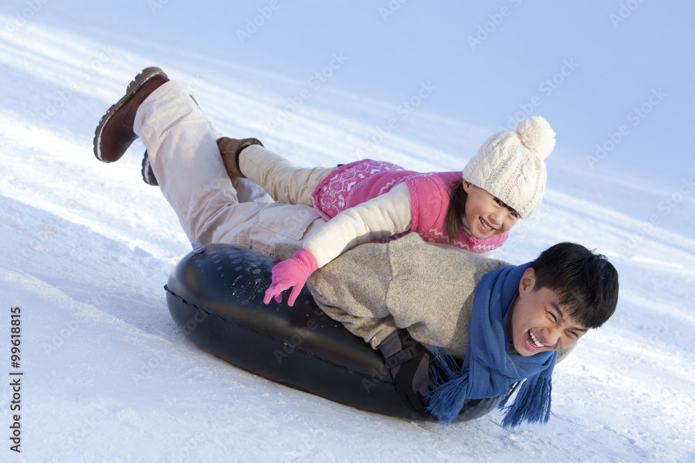 Father and daughter having fun in snow