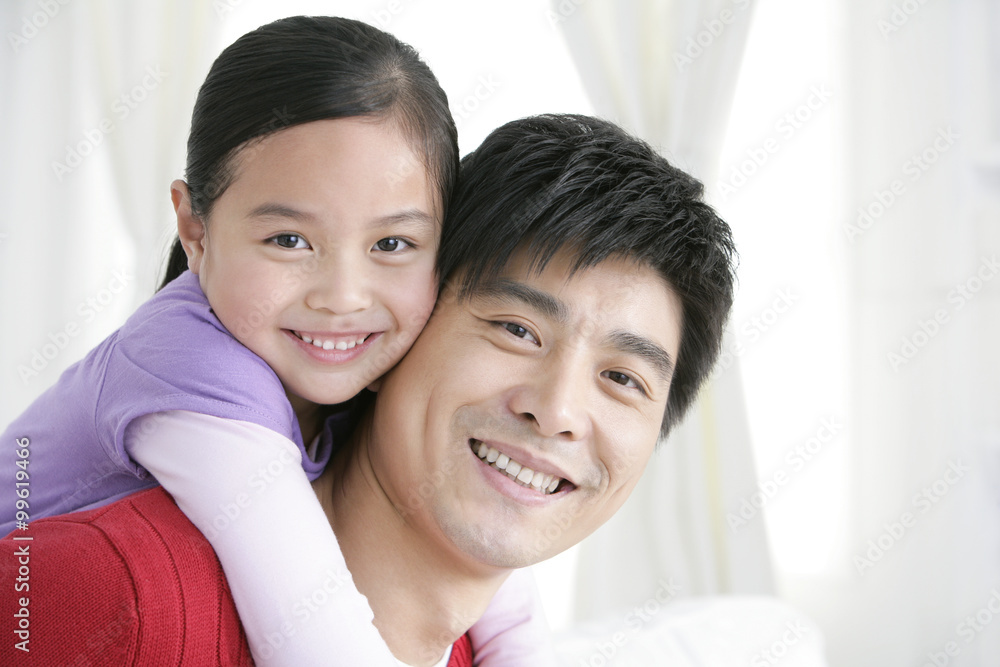 Chinese daughter embracing father from behind