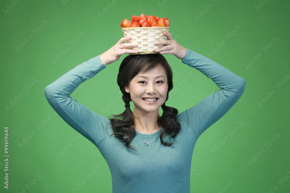 Woman on green background with strawberries