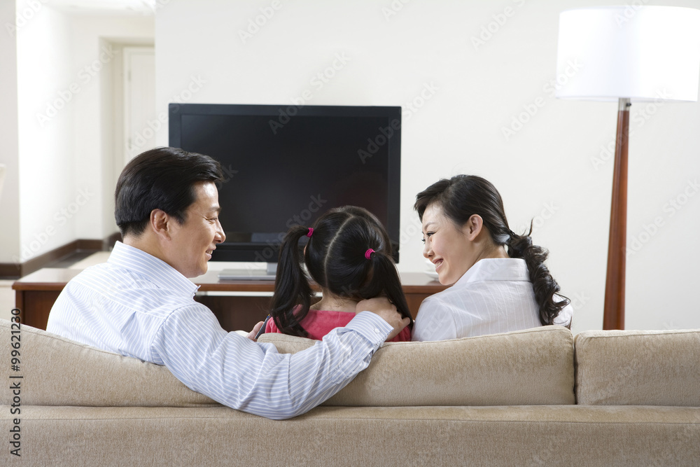 Couple with child in front of widescreen television