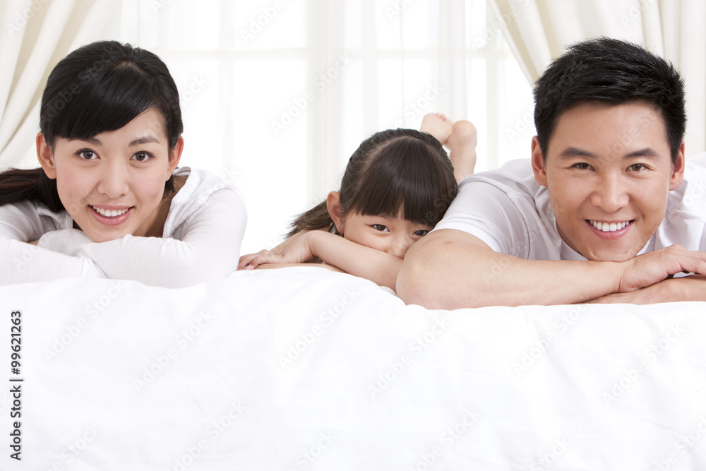 Happy family lying in bed