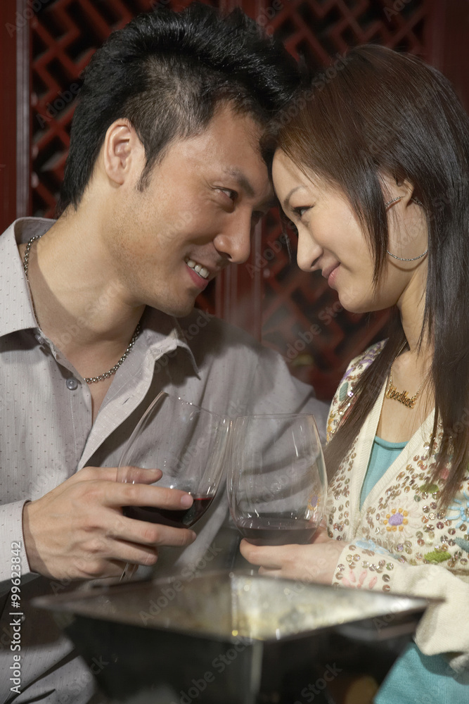 Couple Gazing Into Each Others Eyes Whilst Toasting Their Wine Glasses