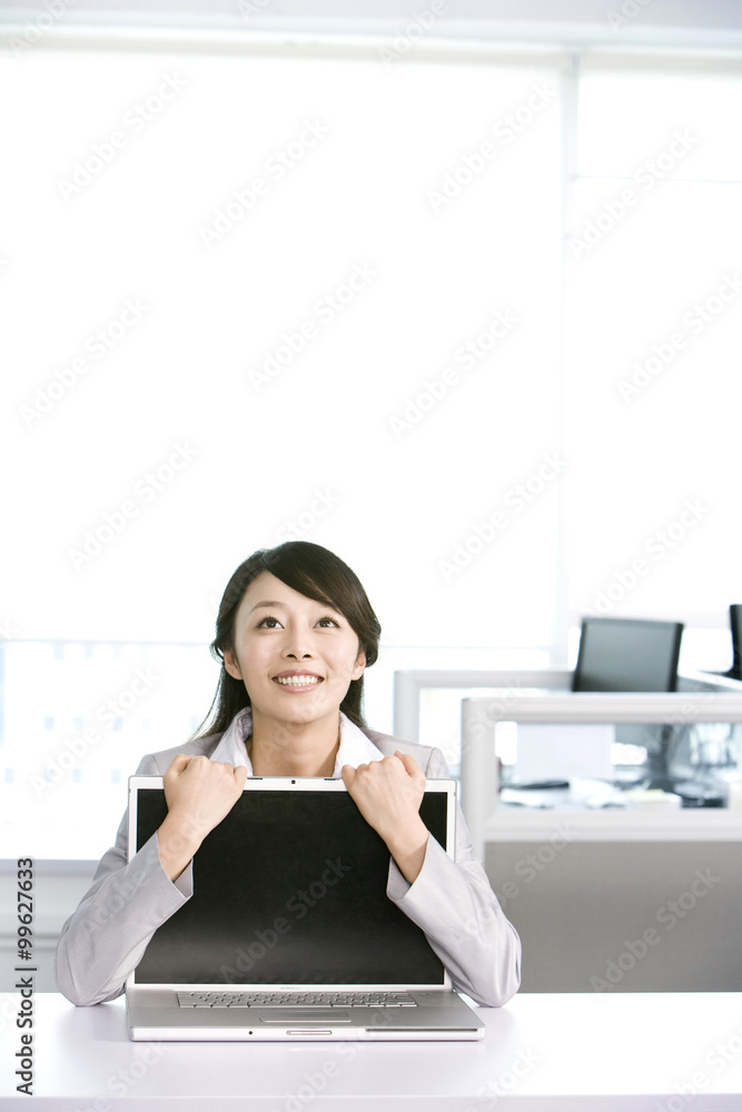 Office worker hugging her computer