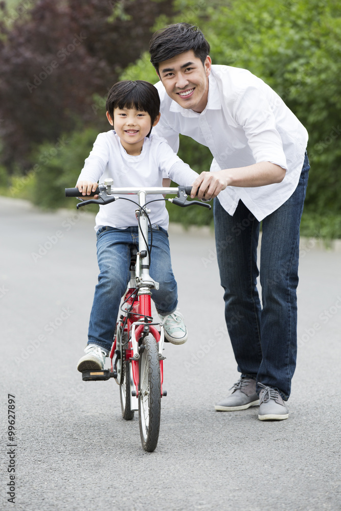 Father teaching son to ride a bicycle