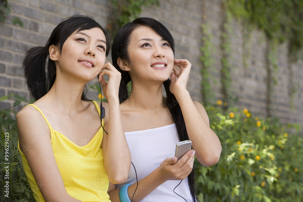 Two friends listen to music