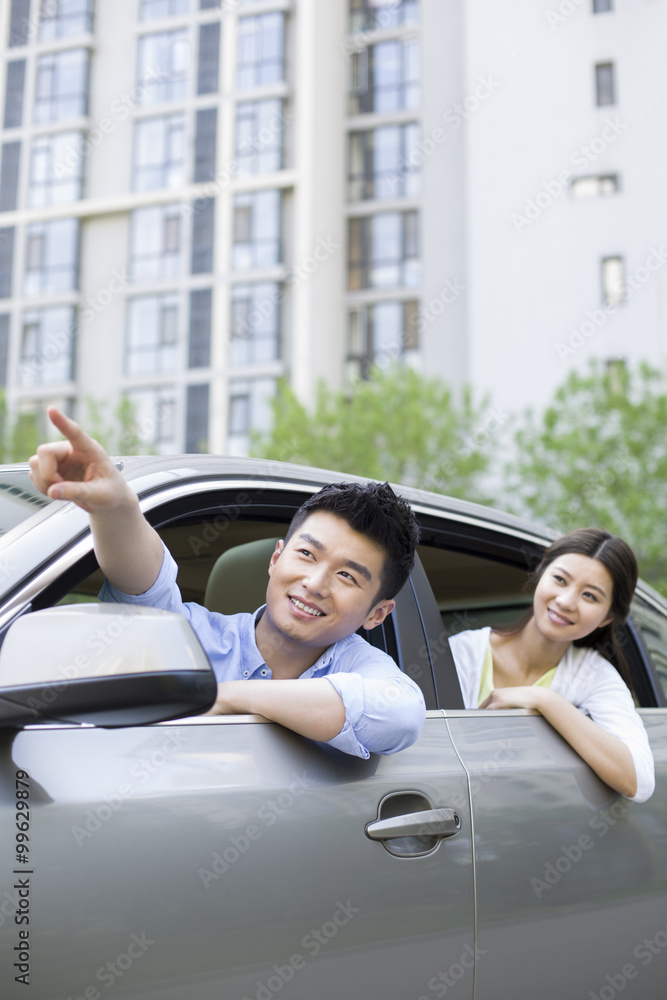 Happy young couple in a car