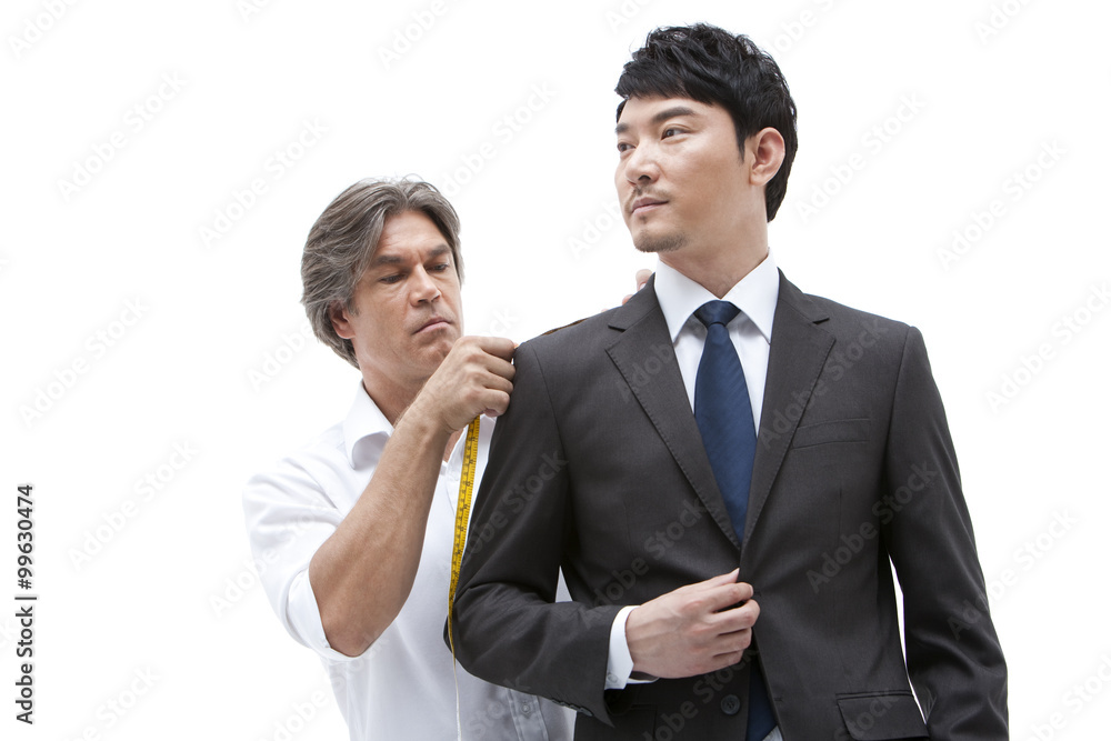 Fashion designer taking a measurement of  businessman