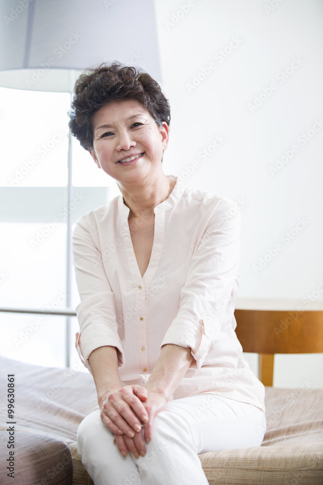 Happy senior woman sitting in sofa