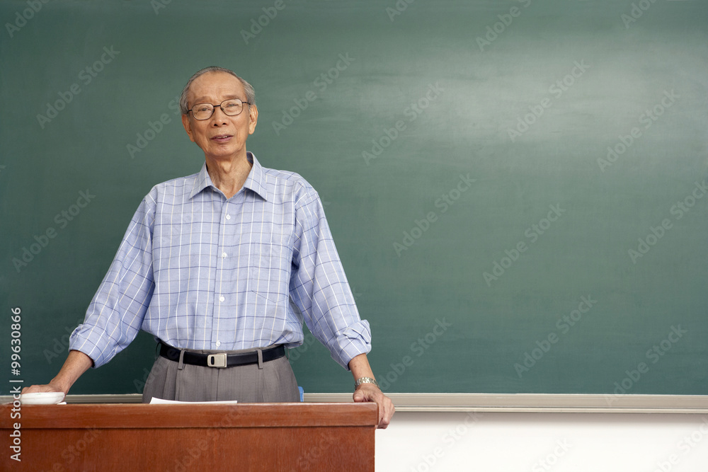 Teacher Standing Behind Desk