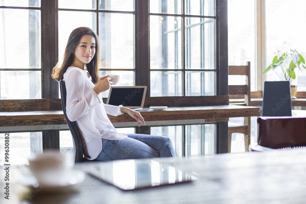 Young woman drinking coffee in cafe