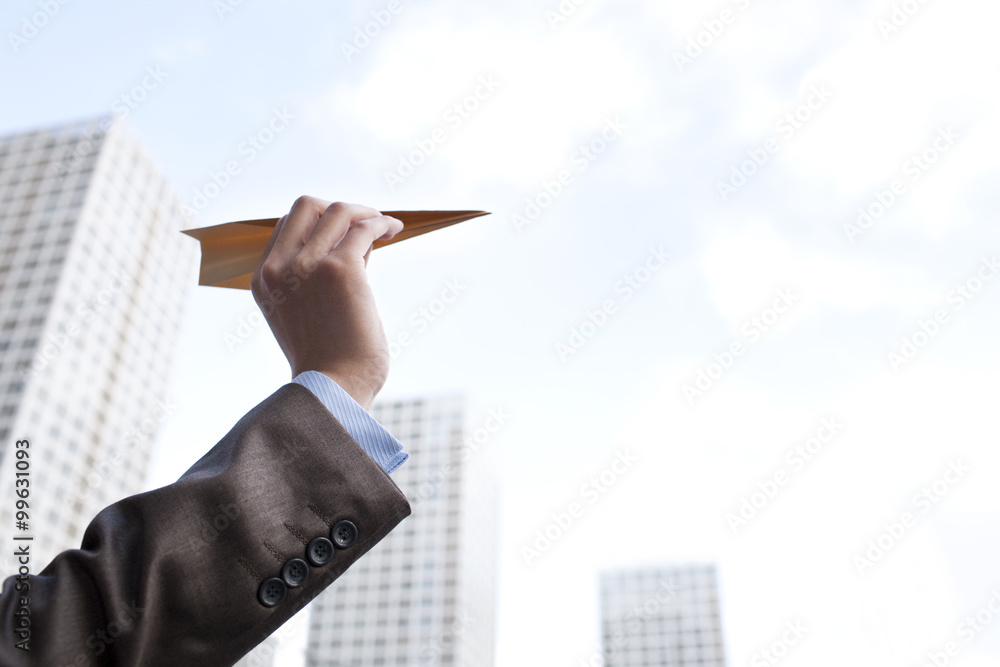 Close-up of hand holding a paper plane