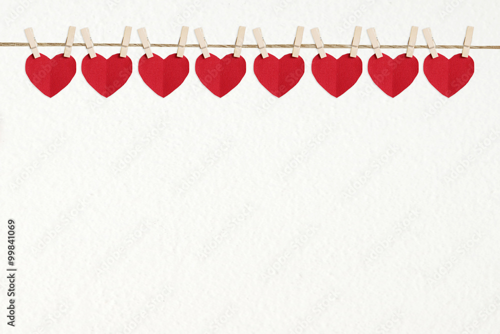 Red heart shape fabric hanging on white wall background