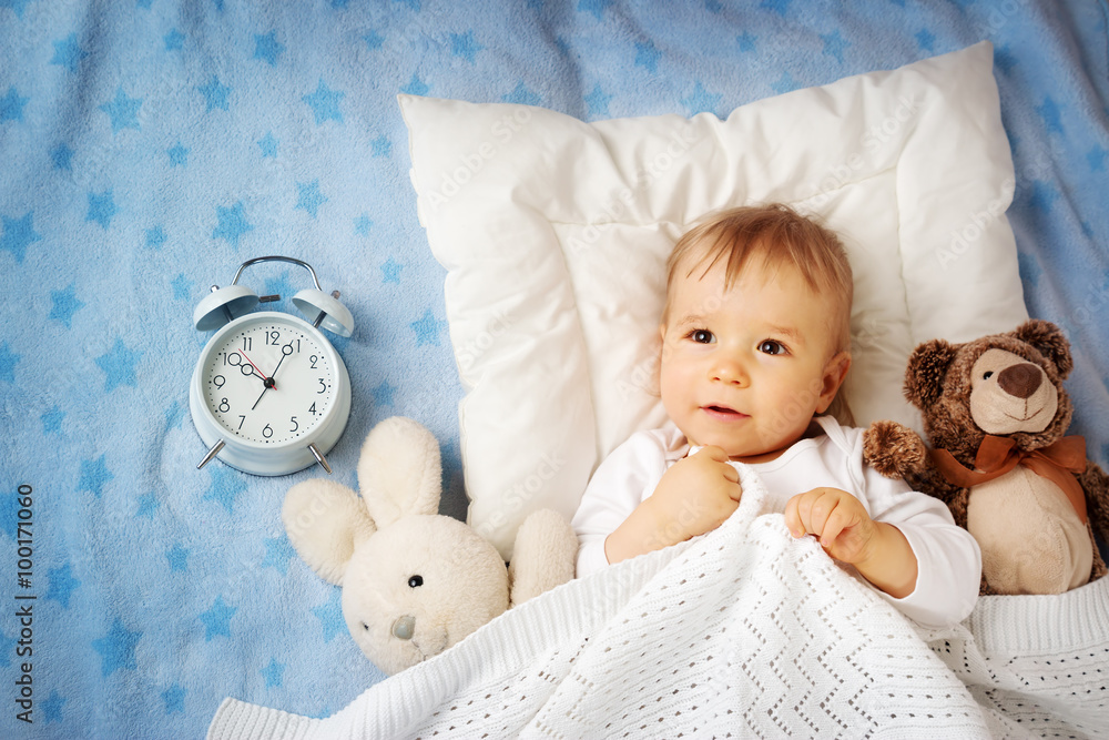 One year old baby with alarm clock