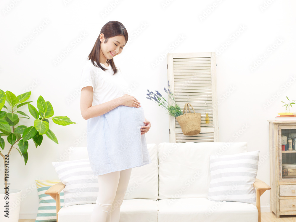 部屋に立つ妊婦