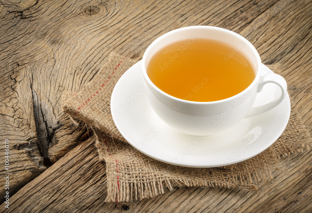 Cup of tea and chamomiles on wooden background