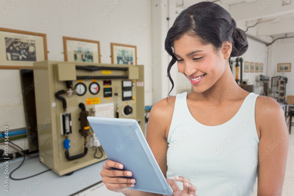 Composite image of smiling businesswoman using digital tablet