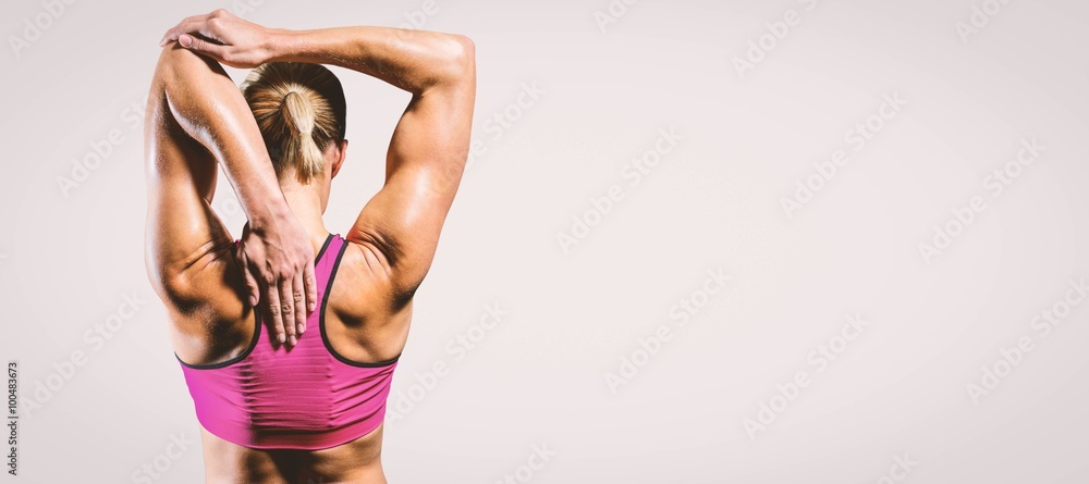 Composite image of muscular woman stretching her arms 