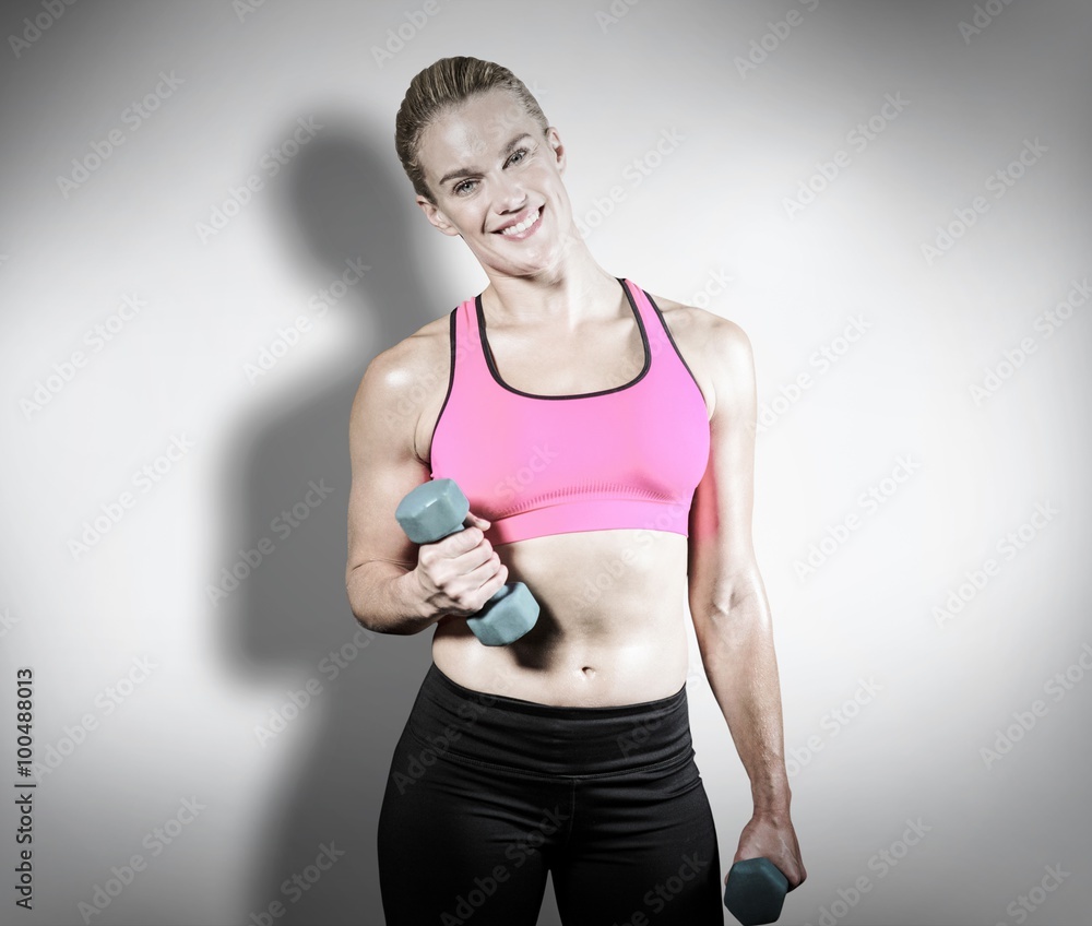 Composite image of muscular woman lifting heavy dumbbells