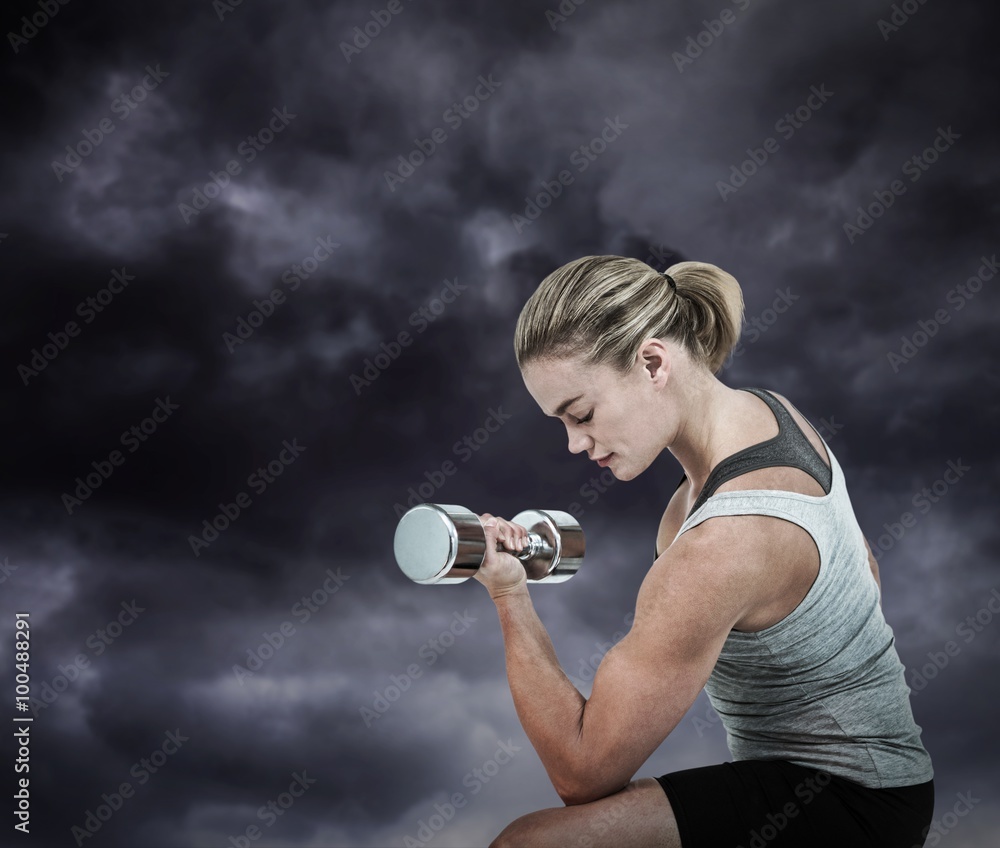 Composite image of  muscular woman working out with dumbbells 