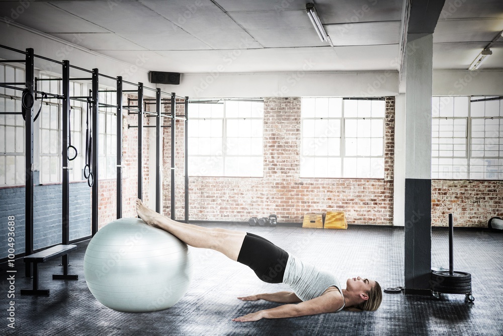 Composite image of  muscular woman lying on floor with legs  