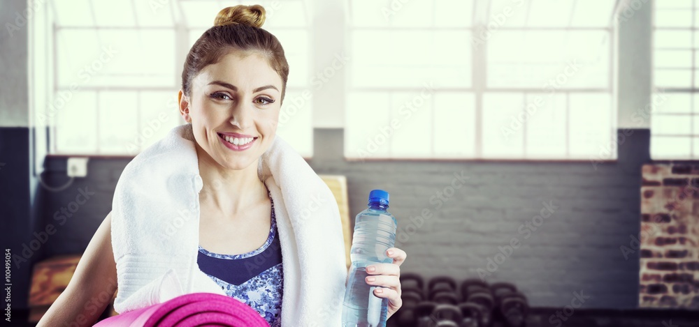 Composite image of fit brunette holding yoga mat