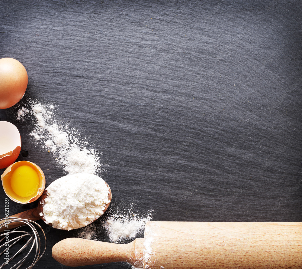 Dough preparation. Baking ingredients: egg and flour on black bo