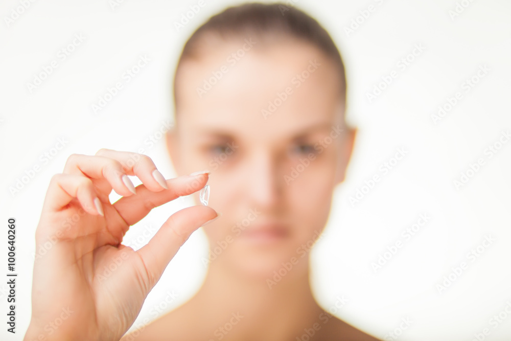 Woman with contact lens on finger healthcare concept