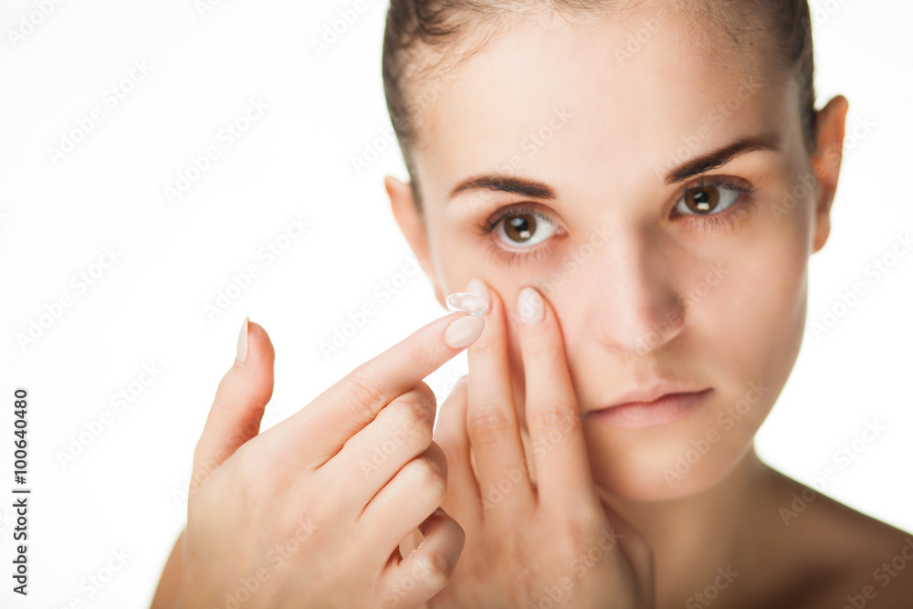 Woman putting contact lens in her eye