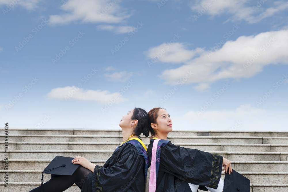 Beautiful female graduates wearing a graduation gown