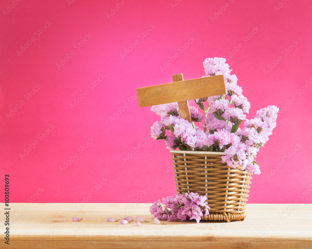 sweet statice flower in basket with blank wooden label 