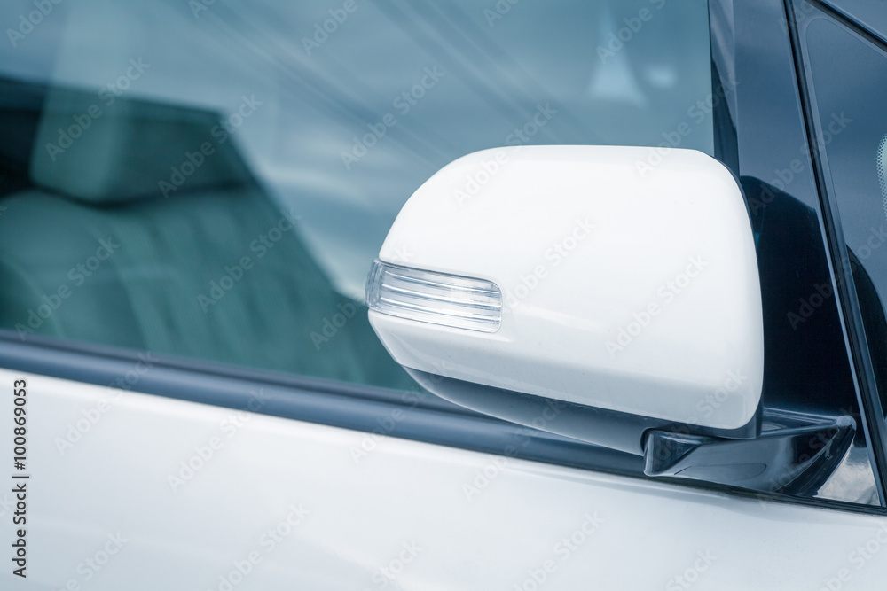 Side rear-view mirror closed for safety at car park.