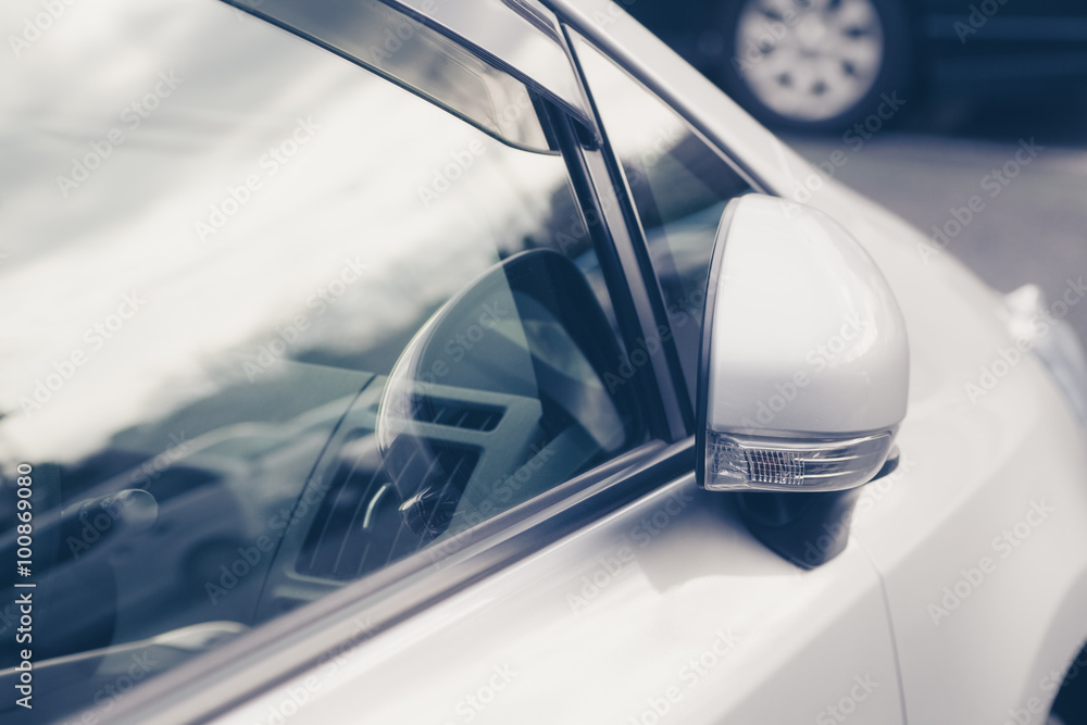 Side rear-view mirror closed for safety at car park.