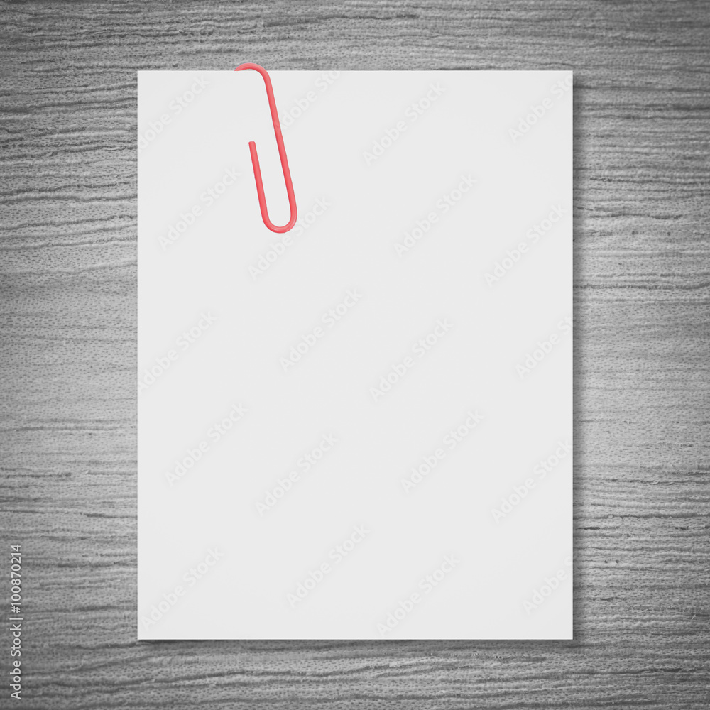 White blank space and red paper clip on wood background