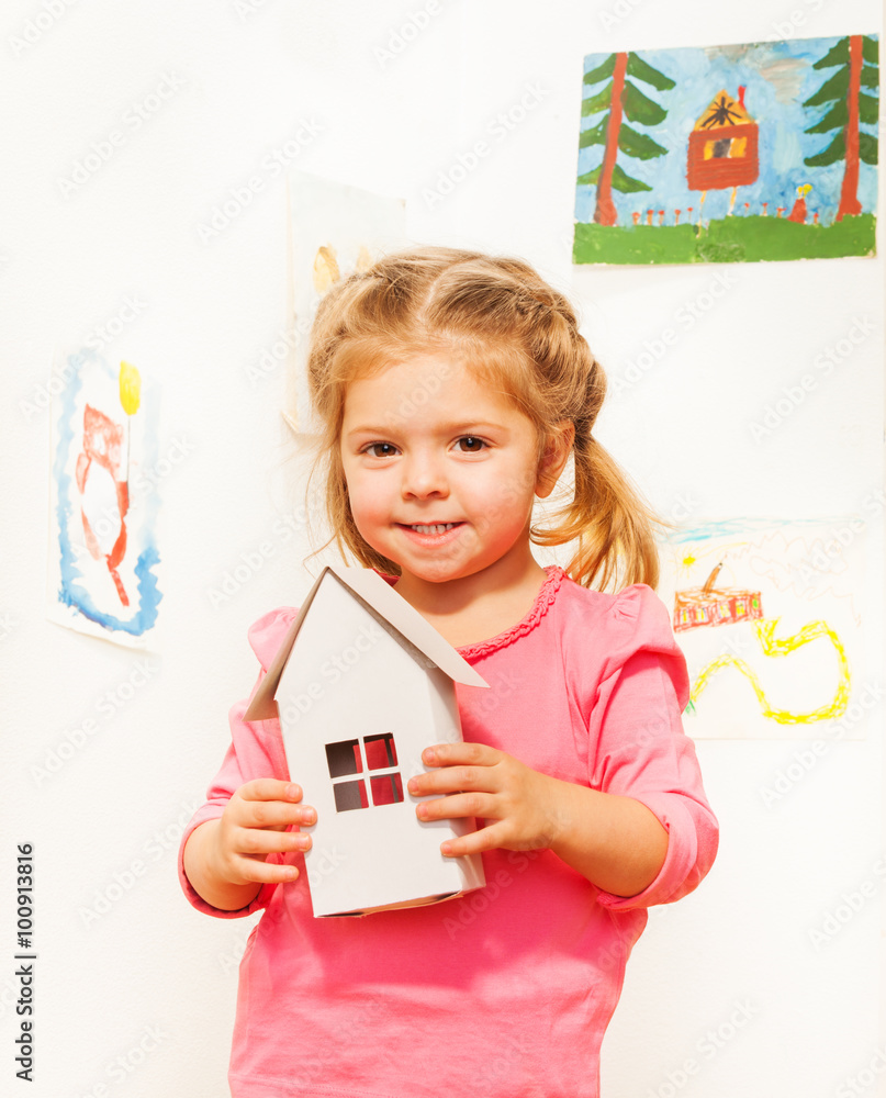 Beautiful girl with cardboard white doll house