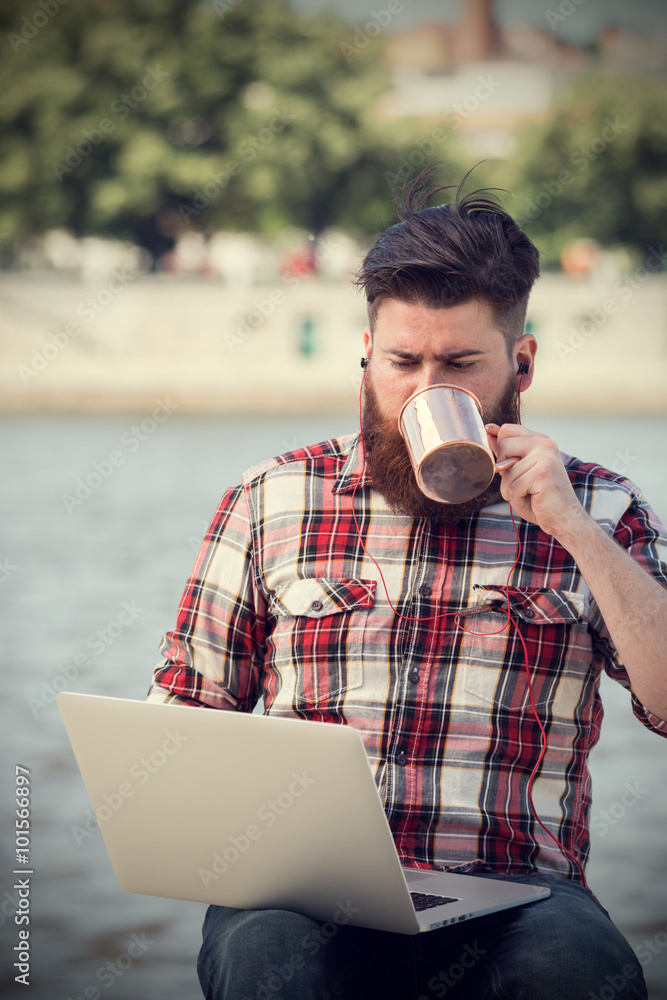 Young hipster man using laptop