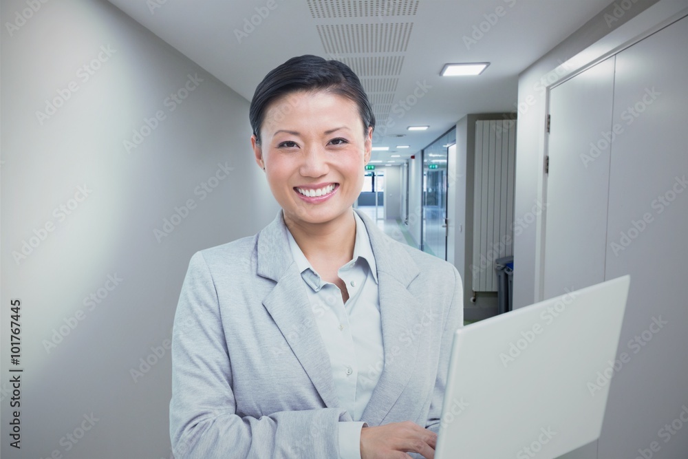 Composite image of businesswoman using laptop with colleagues