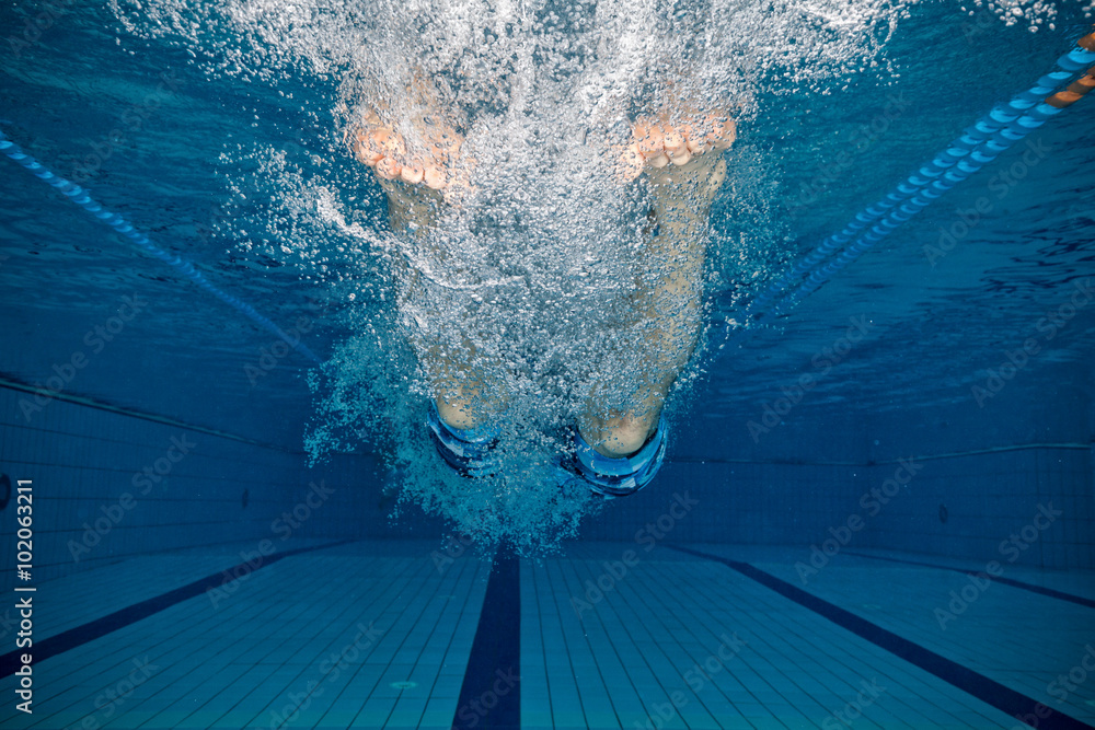 Legs of man jumping into pool