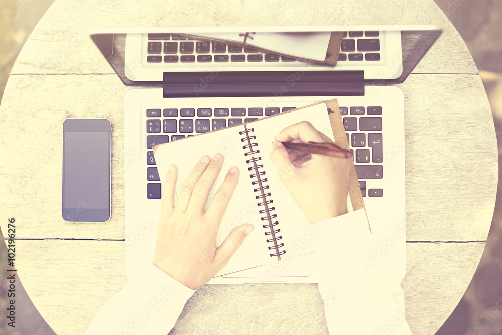 Top view of a woman writes notes in notepad