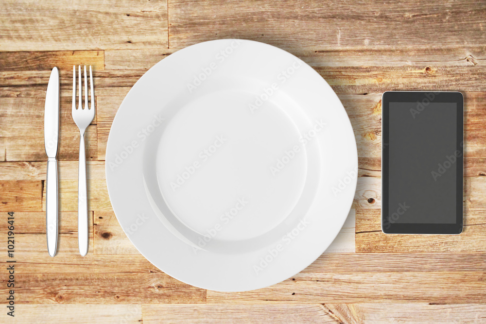 Plate and cell phone on a wooden table