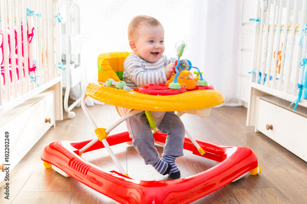 First steps of the boy in a baby walker