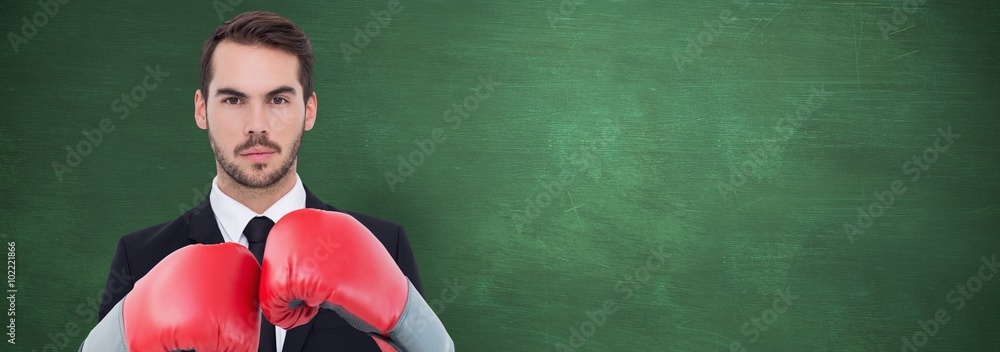 Composite image of businessman with boxing gloves