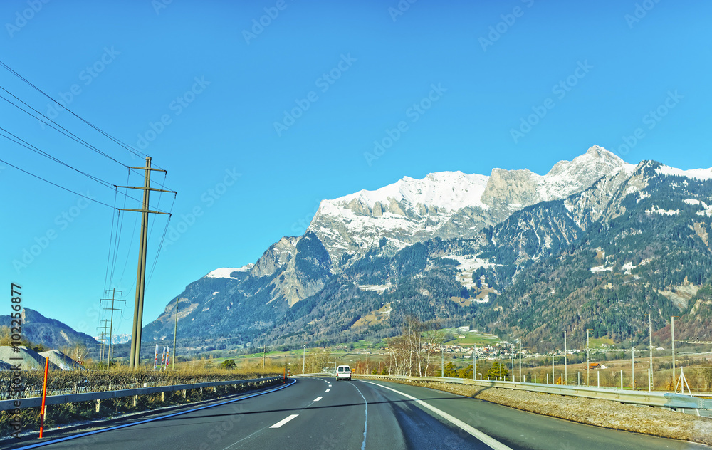 冬季有输电线路和汽车的道路Switz