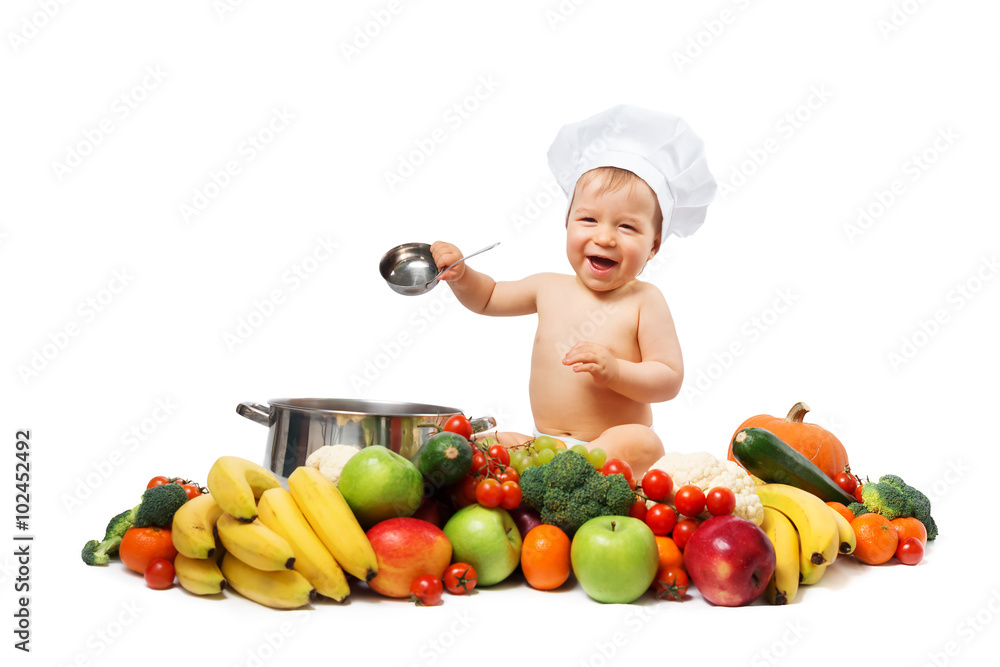 Baby boy in chef hat with cooking pan and vegetables