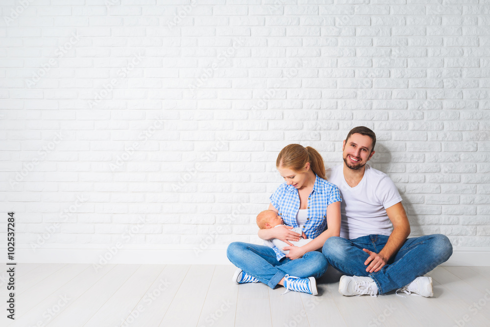 happy family mother, father of a newborn baby on floor near blan