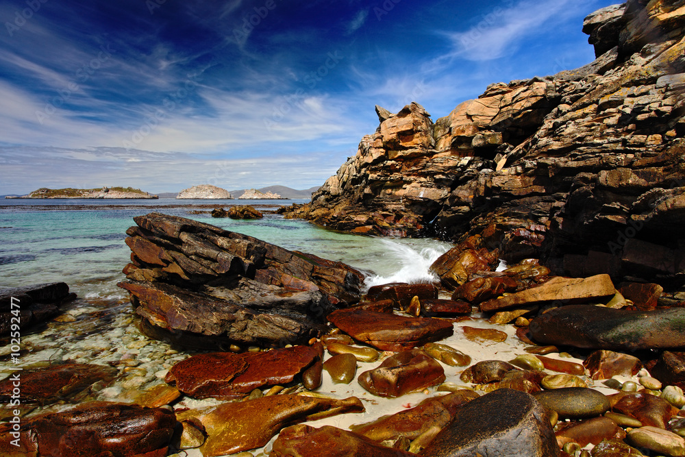 蓝色的大海和天空，海浪拍打着海岸，美丽的岩石海岸，美国加利福尼亚州